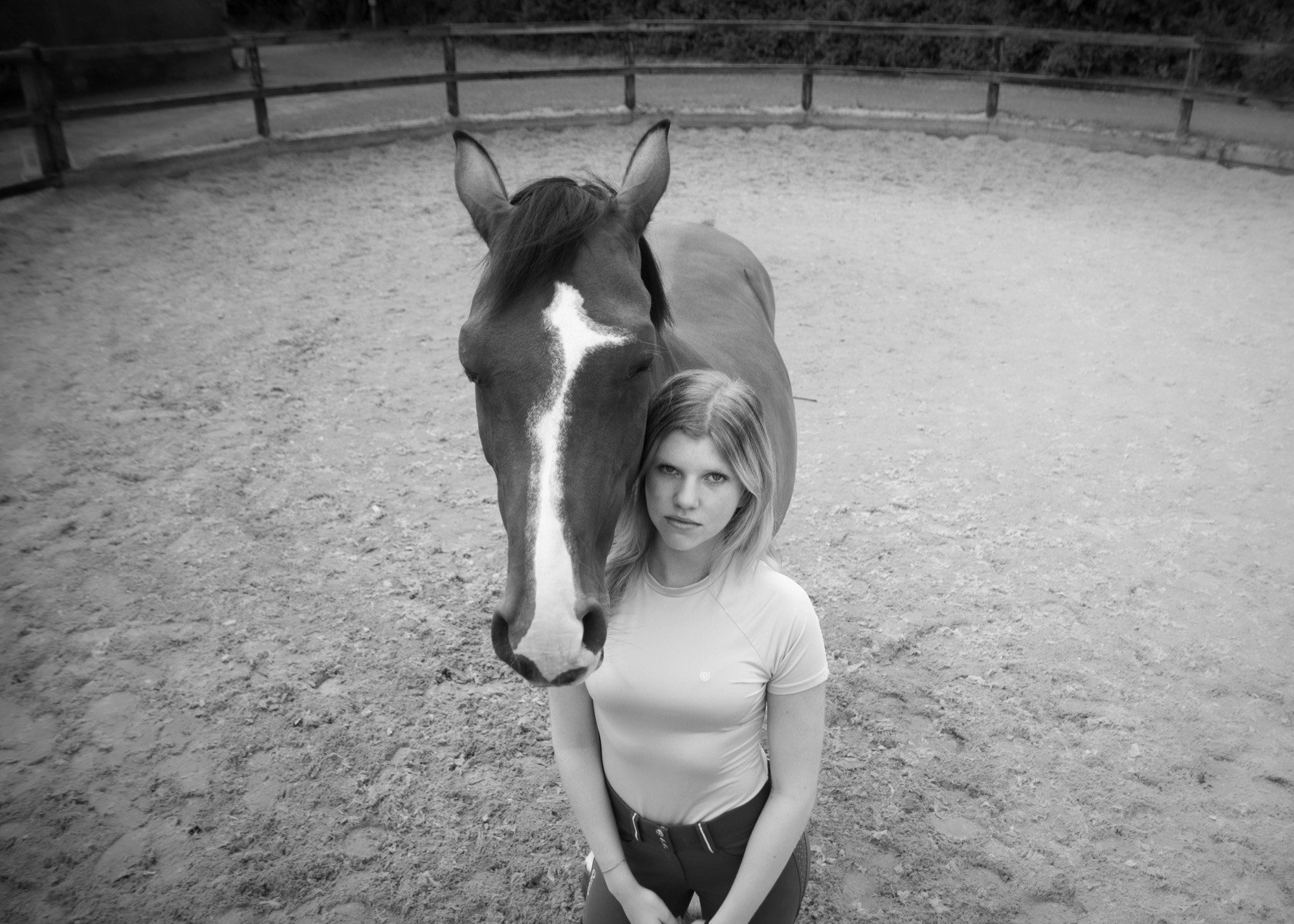 Leerling staat naast haar paard in de bak