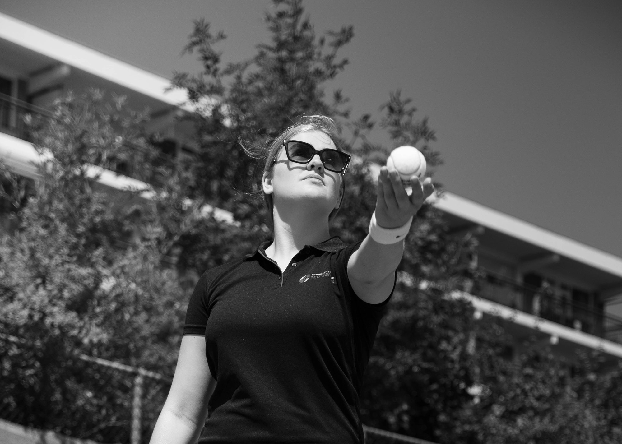 Leerling houdt de tennisbal omhoog voor haar opslag